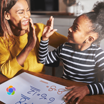 Parent and tween giving a high-five at the kitchen table