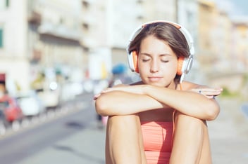 teenager sat listening to headphones to deal with emotions
