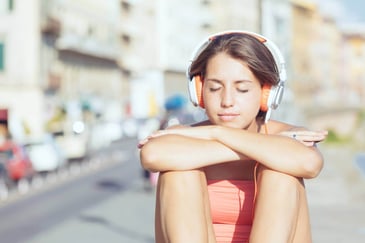 teenager sat listening to headphones to deal with emotions